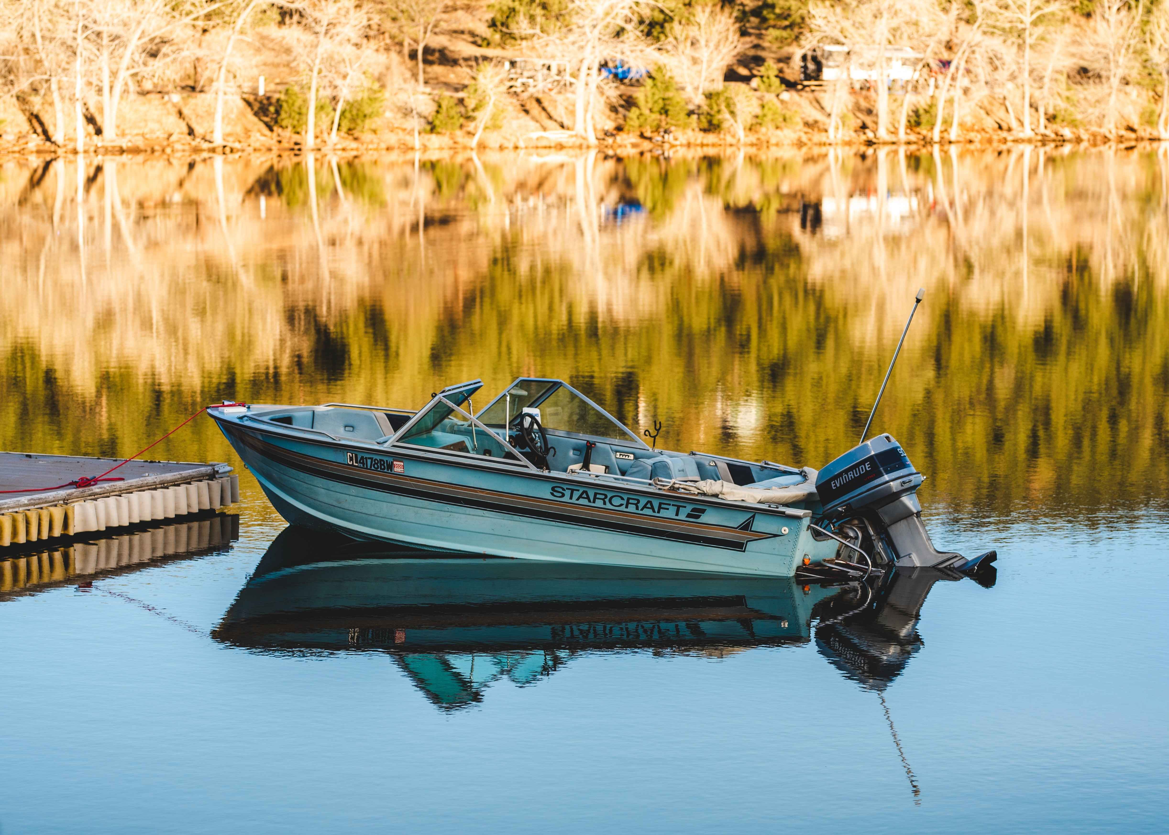 An old Stabicraft boat docked on a lake.