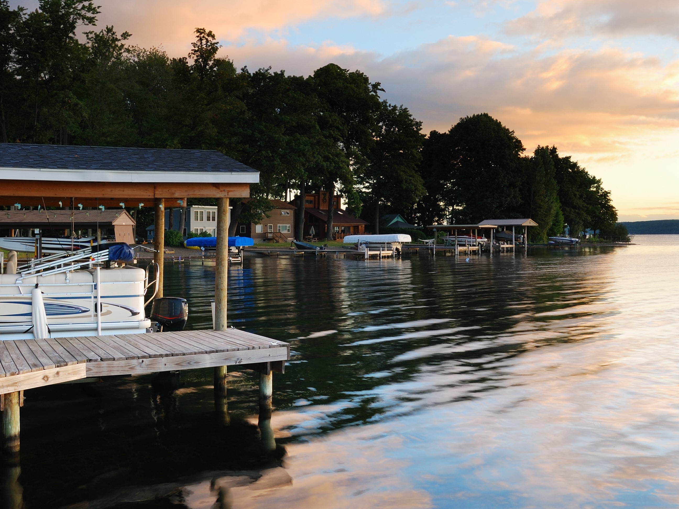 A boat dock on a calm lake at sunrise.