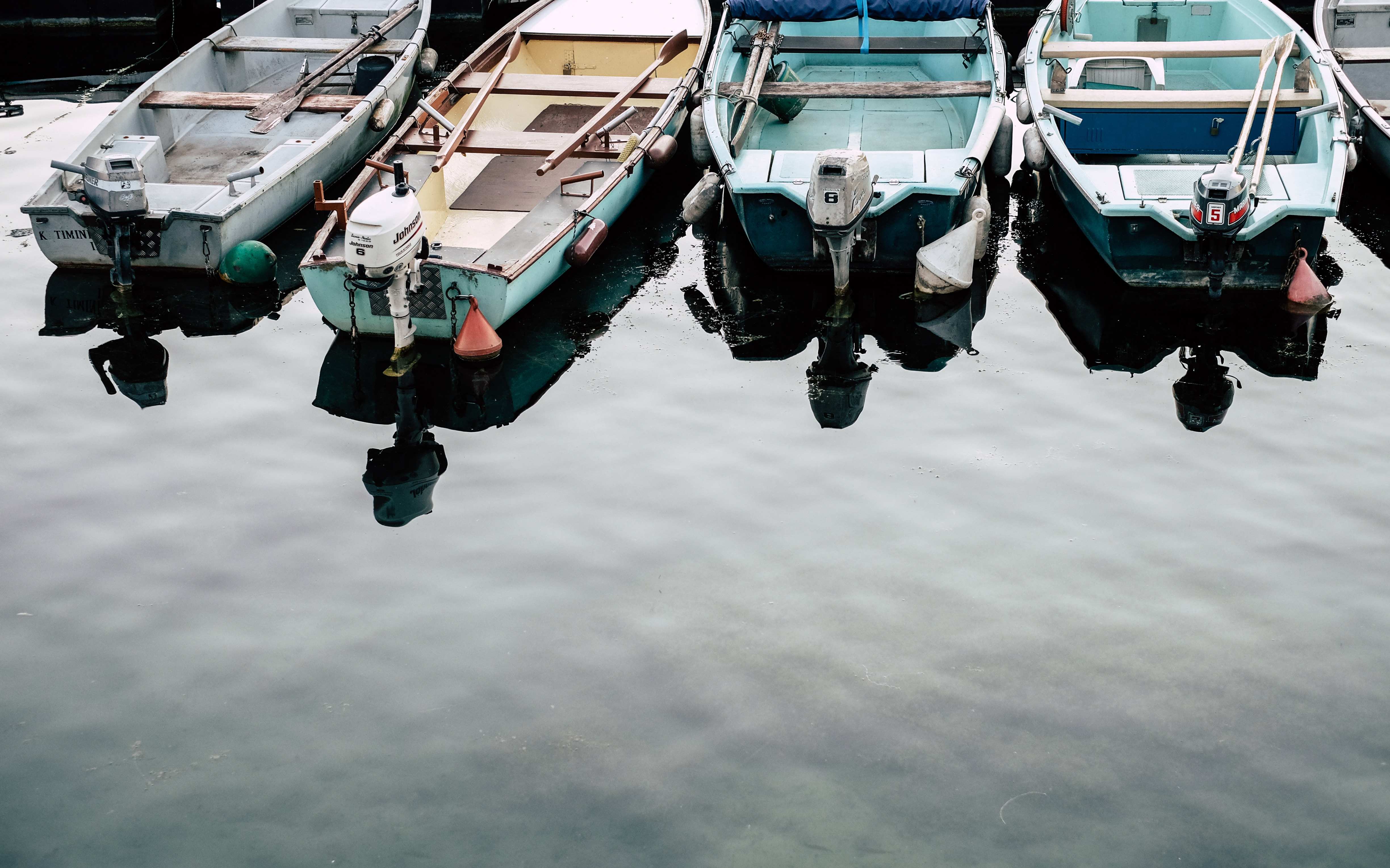 A group of small open boats with outboards attached anchored in shallow waters.